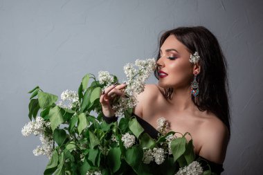 Alerjisi olmayan baharın tadını çıkar. Bahar çiçekleri. Polen alerjisi. Narin bir kadın için nazik bir çiçek. Baştan çıkarıcı esmer kız leylak çiçeği buketi tutuyor. Alerjisi olmayan yaşam. Alerji çiçekleri mevsimi bitti..