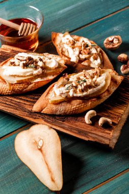 Allah 'ım. Krem peynirli kızarmış crostini, armut ve fındık. İtalyan antipatik atıştırmalıklarıyla aperatifler. en üstteki görünüm.