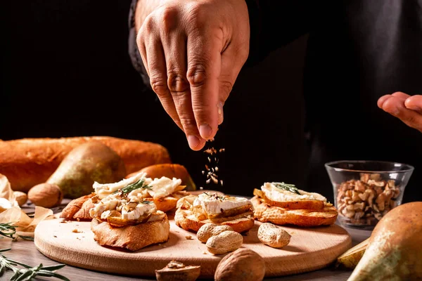 梨と前菜Bruschetta クルミとブリーは シェフの手でチーズ料理をカマンベール 前菜テーブルにイタリアのアンティパスティスナック テキストの空間 — ストック写真