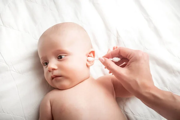 スワブで母親のクリーニング赤ちゃんの耳のクローズアップ コンセプト衛生洗浄 — ストック写真