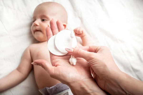 綿棒で赤ちゃんの耳をきれいにする母親の手の写真を閉じます コンセプト衛生洗浄 — ストック写真