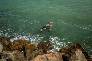 Erkek dalış dalgıcı okyanus sahilden dalmadan önce maske ve şnorkel ayarlıyor..
