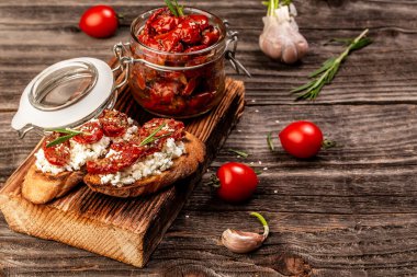 Keçi peynirli bruschetta, ışık masasında güneşte kurutulmuş domates, üst manzara yemek tarifi arka planı. Kapat..
