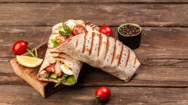 Kuşkonmaz, vişneli domates, avokado, tavuk fileto ve taze salata ile tortilla dürümü. Sağlıklı yemek. Üst Manzara. Uzun afiş biçimi. Metin için boşluk.