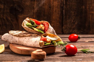 Kuşkonmaz, vişneli domates, avokado, tavuk fileto ve taze salata ile tortilla dürümü. Sağlıklı yemek. Üst Manzara. Metin için boşluk.