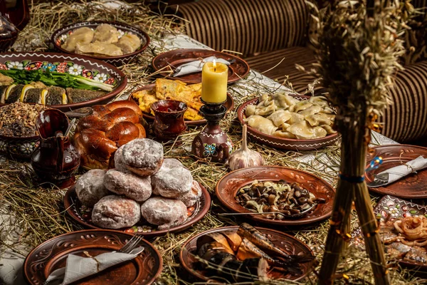 Traditional Christmas table in Ukraine, twelve meatless dishes: kutya, stewed fruit, beet soup, dumplings, fried fish, pickled mushrooms, garlic. — Stock Image Traditional Christmas Table Ukraine Twelve Meatless Dishes Kutya Stewed Fruit Stock Photo