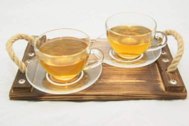 Beyaz arka planda iki fincan yeşil çay.