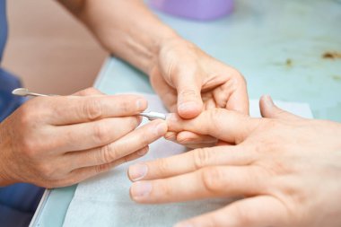 Adam kuaförde manikür yapıyor.