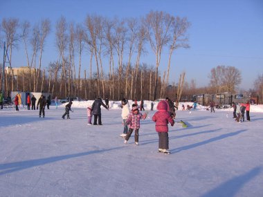 Rusya, Novosibirsk, 15 Ocak 2012: neşeli çocuklar kış mevsiminde buz üstünde buz pateni oynuyorlar.