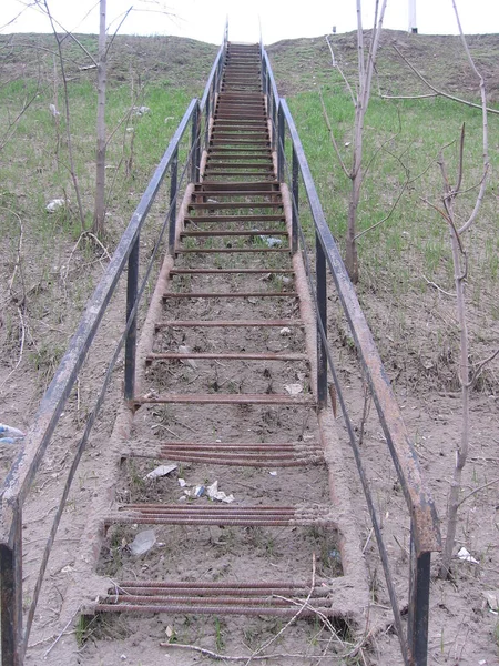 Старая грязная металлическая лестница на склоне ведет вверх — стоковое фото