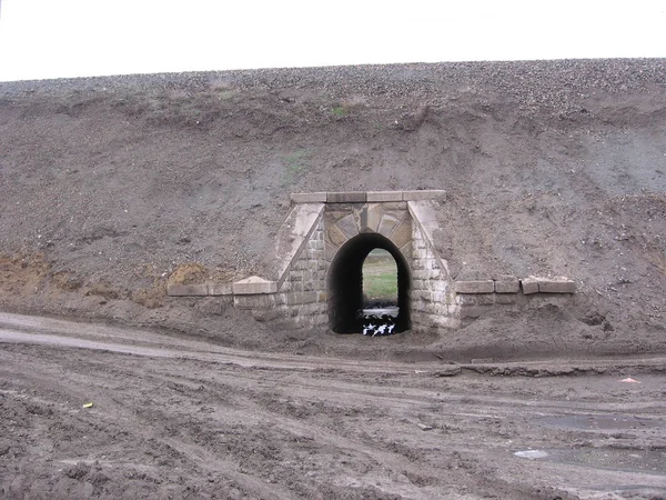 堤岸下的半圆形石拱形建筑;堤岸下的通道 — 图库照片