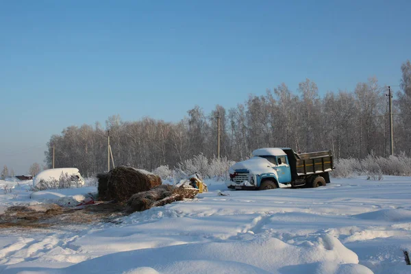 Porzucony stary samochód ciężarowy w pobliżu stodoły z sianem w zimie agricultura — Zdjęcie stockowe