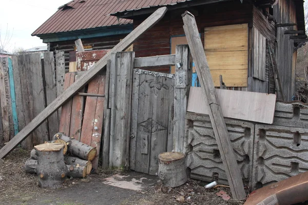 村子里被毁的老房子 用肮脏的栅栏围住 上面标有愤怒的狗和装饰过的雕花大门 — 图库照片