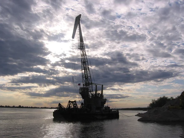 Nehir limanında kum madenciliğinde yüksek kargo vinci.