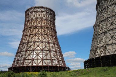 Büyük bir boru termik santraldeki soğutma kulesi çitlerin arkasındaki kapalı bir alanda bir Chp fabrikasının inşaatını ısıtmak için.