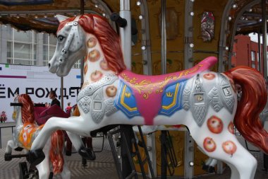 Rusya, Novosibirsk 30.06.2019: Oyuncak at atlıkarınca çocuk eğlencesi ve ata binmek için parka gelir