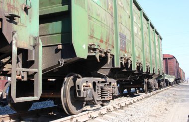 Rusya, Novosibirsk 23.04.2019: Kargo taşımacılığı için demiryolu vagonları elektrikli trenin raylarında uçan metal tekerleklerle gönderiliyor.