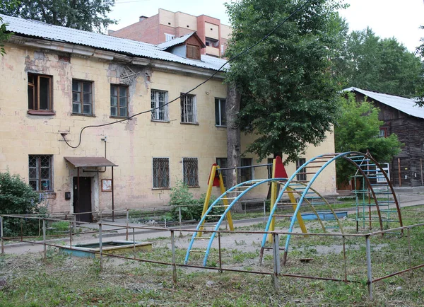 Een Oud Appartementencomplex Met Een Geruïneerde Gevel Vuile Kinderspeelplaats Met — Stockfoto