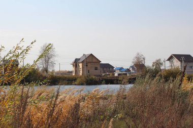 Sonbaharda göl kenarında evleri olan bir köy.