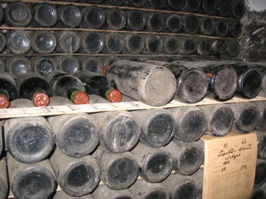 Ukrayna, Kırım 26.09.2010: Eski tozlu şarap şişeleri şaraphanenin antik deposunda yatıyor