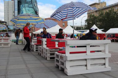 Rusya, Novosibirsk 30.06.2019: İnsanlar sokaktaki bir kafede dinleniyor ve sokaktaki bir restoranda öğle yemeği yiyorlar.