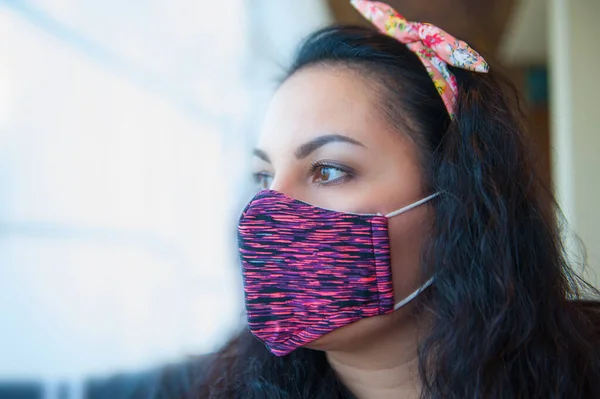 Cama bakan parlak yüzlü esmer bir kadının portresi. Coronavirus covid 19 yüzünden hastanede bir kadın var.