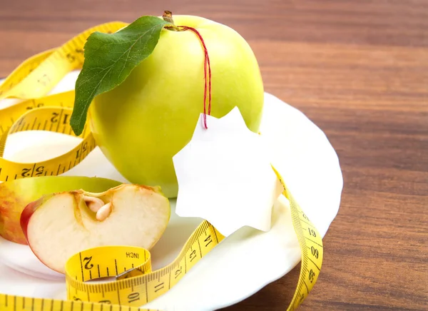 Dietas y alimentos saludables. Amarillo, manzana verde con hoja, cinta y — Foto de Stock
