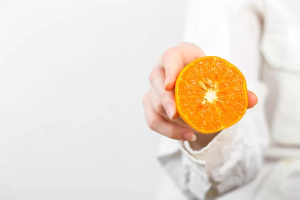 Mujer Hand Sujetando una naranja aislada en blanco —  Fotos de Stock