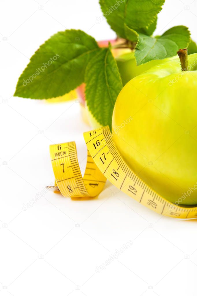 dieting. green, yellow apple with leaf and tape isolated on a wh