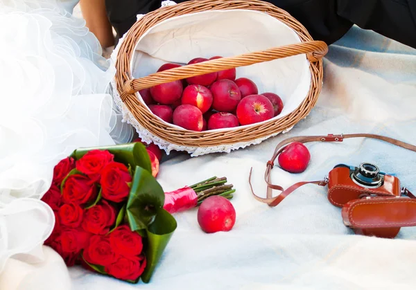Wedding picnic with apple, bouquet of rose and old camera — Stock Photo, Image