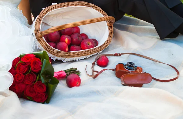 Picnic de boda con manzana, ramo de rosa y cámara vieja — Foto de Stock