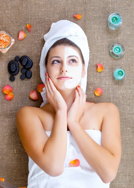 Meisje met gezichtsmasker op een stenen therapie, hete steen massage — Stockfoto