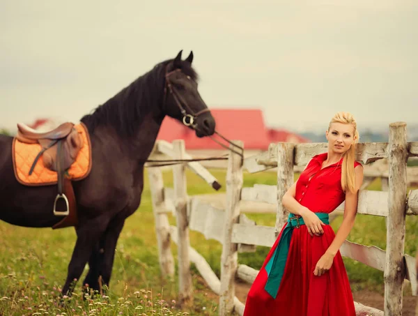 Schöne junge Frau mit einem Pferd im Freien — Stockfoto