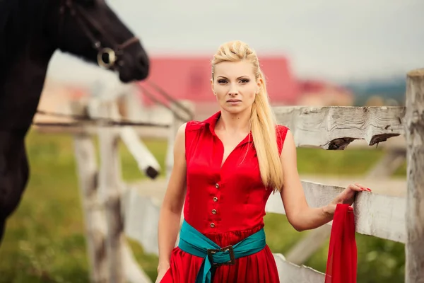 Mulher bonita com um cavalo ao ar livre — Fotografia de Stock