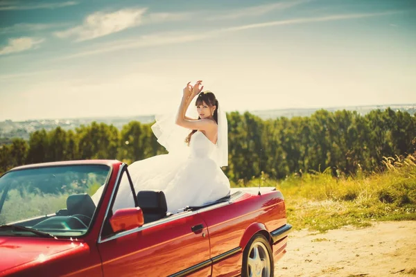 Сбежавшая невеста. Красивая женщина на красном кабриолете — стоковое фото