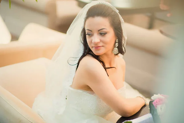Foto de uma bela noiva morena em um vestido de casamento luxuoso — Fotografia de Stock