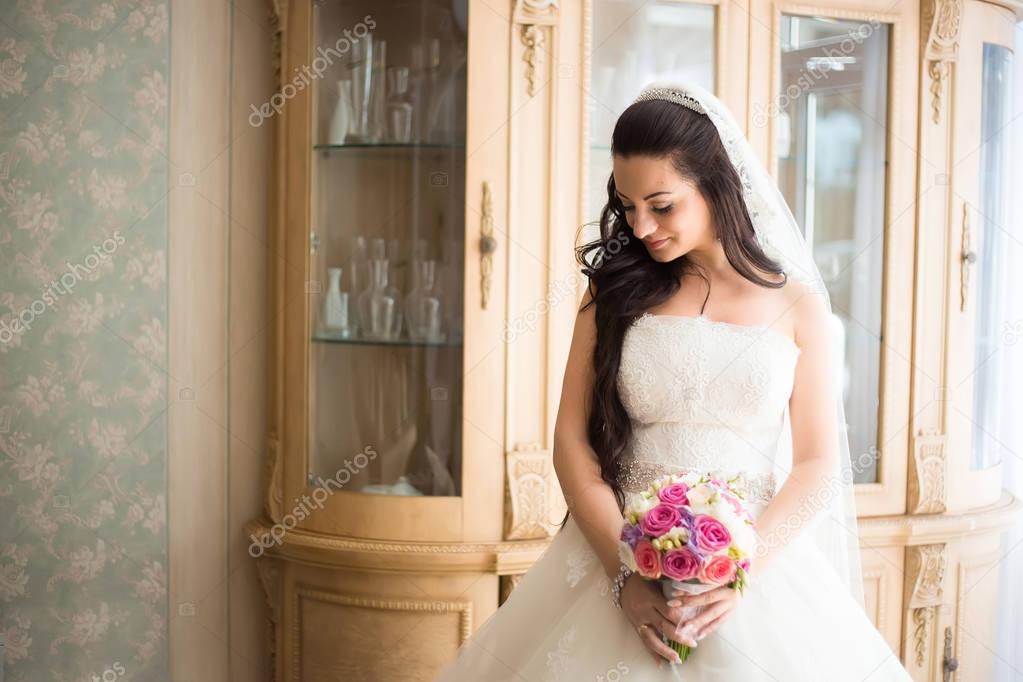 Gorgeous bride in wedding dress in luxury interior with diamond 