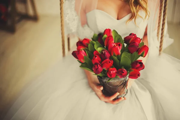 Hermosos tulipanes rojos de boda en manos de novias — Foto de Stock