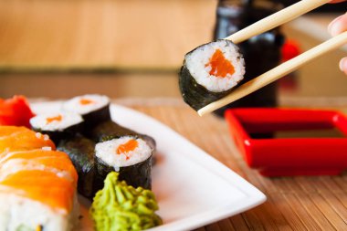 suşi yemek çubukları tutmak ve sosun daldırma