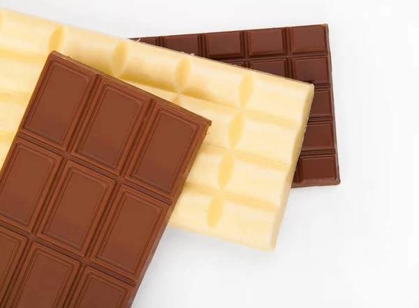 Diferentes tipos de chocolate en una pila sobre fondo blanco —  Fotos de Stock