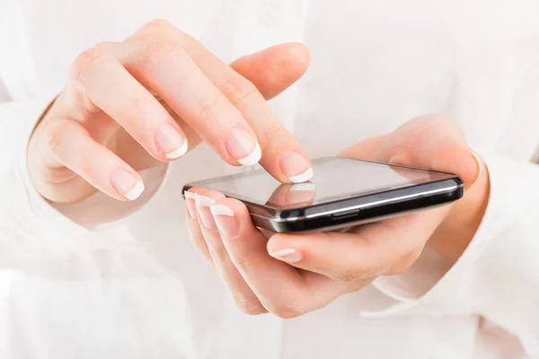 Geschäftsfrau mit jungen Händen und schönen Nägeln mit dem Handy — Stockfoto
