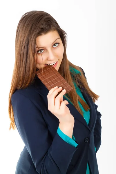 Bonita mujer de negocios comiendo una barra de chocolate contra una b blanca —  Fotos de Stock