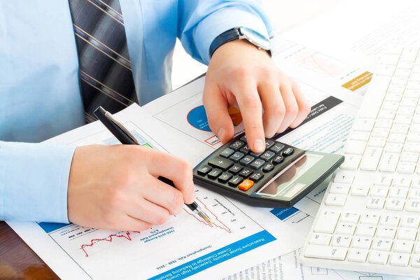 business man at workplace with pen, keyboard, calculator