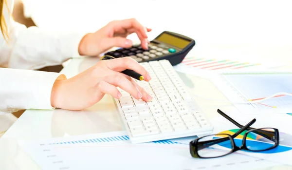 Woman with beautiful hands working on the calculator and keyboar — Stock Photo, Image