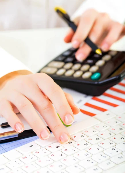 Mulher com belas mãos trabalhando na calculadora e chaveiro — Fotografia de Stock