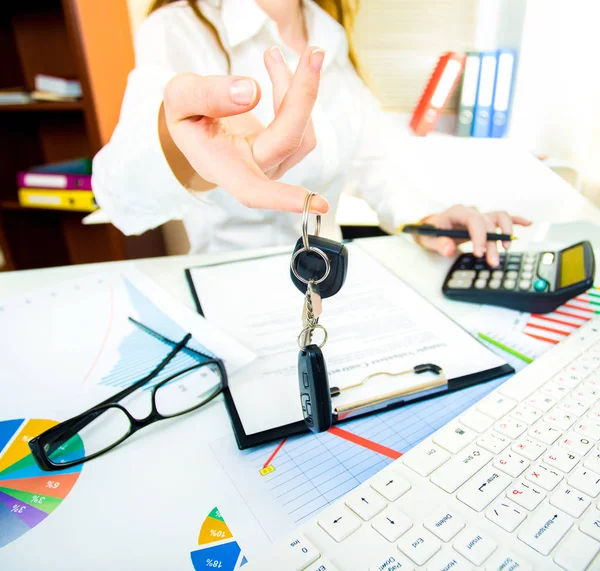 La mano di una donna tiene le chiavi della macchina e la porta elettronica si apre in offi — Foto Stock