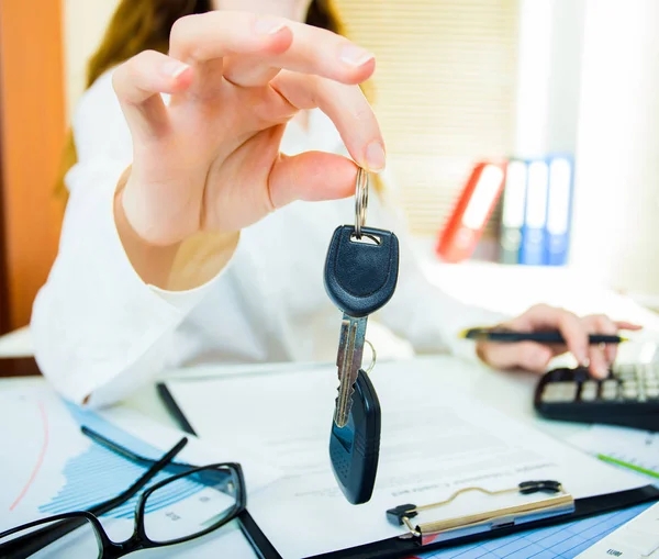 Frau hält Autoschlüssel und elektronische Türentriegelung in der Hand — Stockfoto