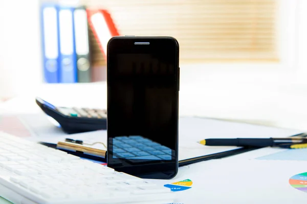 Nuevo teléfono con pantalla táctil en la mesa de oficina con pantalla vacía —  Fotos de Stock