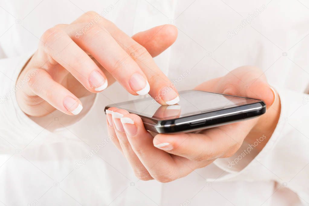 Business woman with young hands and beautiful nails using mobile