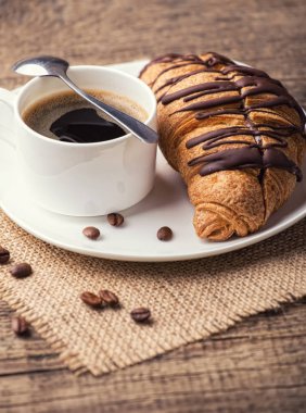 kahve ve kruvasan ahşap masa üzerinde plaka 